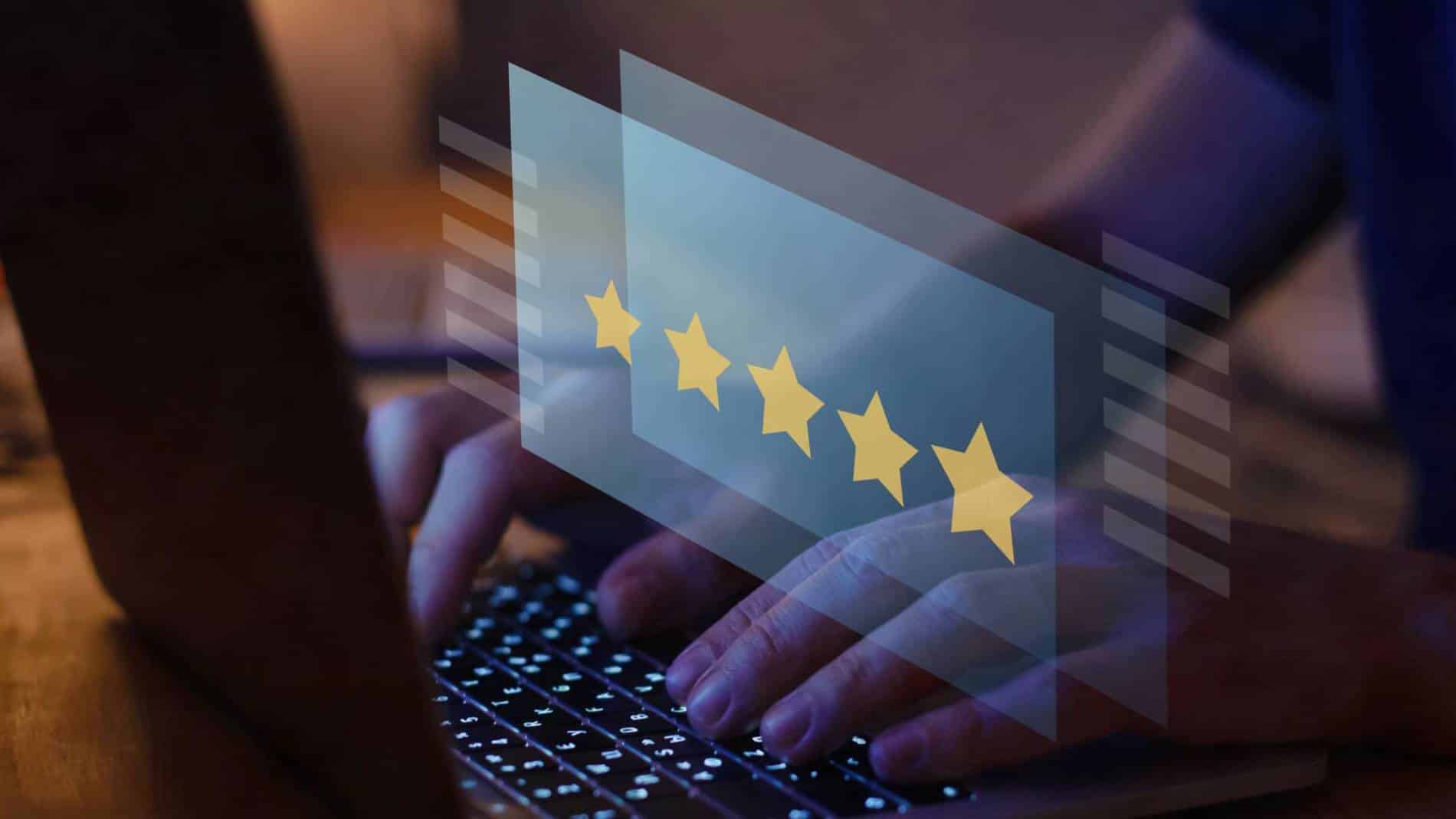 A person using a laptop computer, with a graphic of 5 gold stars, reminiscent of Google Reviews.