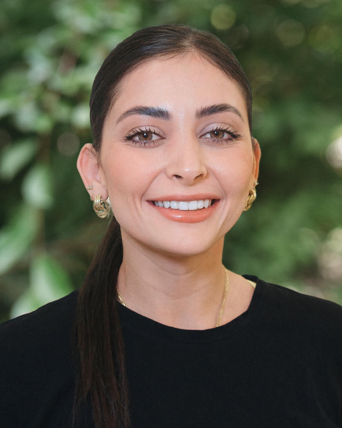 Andrea Gonzales wearing a black top and smiling.