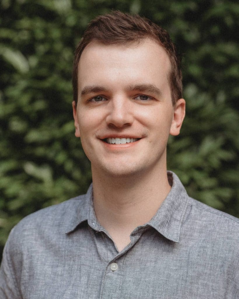 Ben Swofford, smiling and wearing a grey button up shirt.