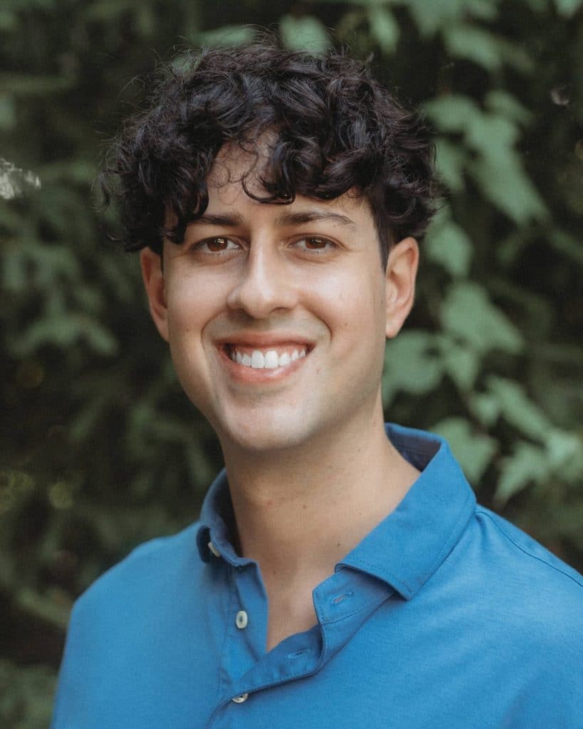 Chris Mendez smiling and wearing a light blue polo shirt.