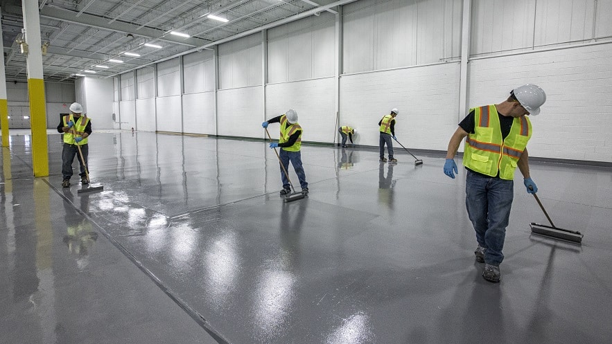 A Stonhard installation team putting the finishing touches on an epoxy floor.